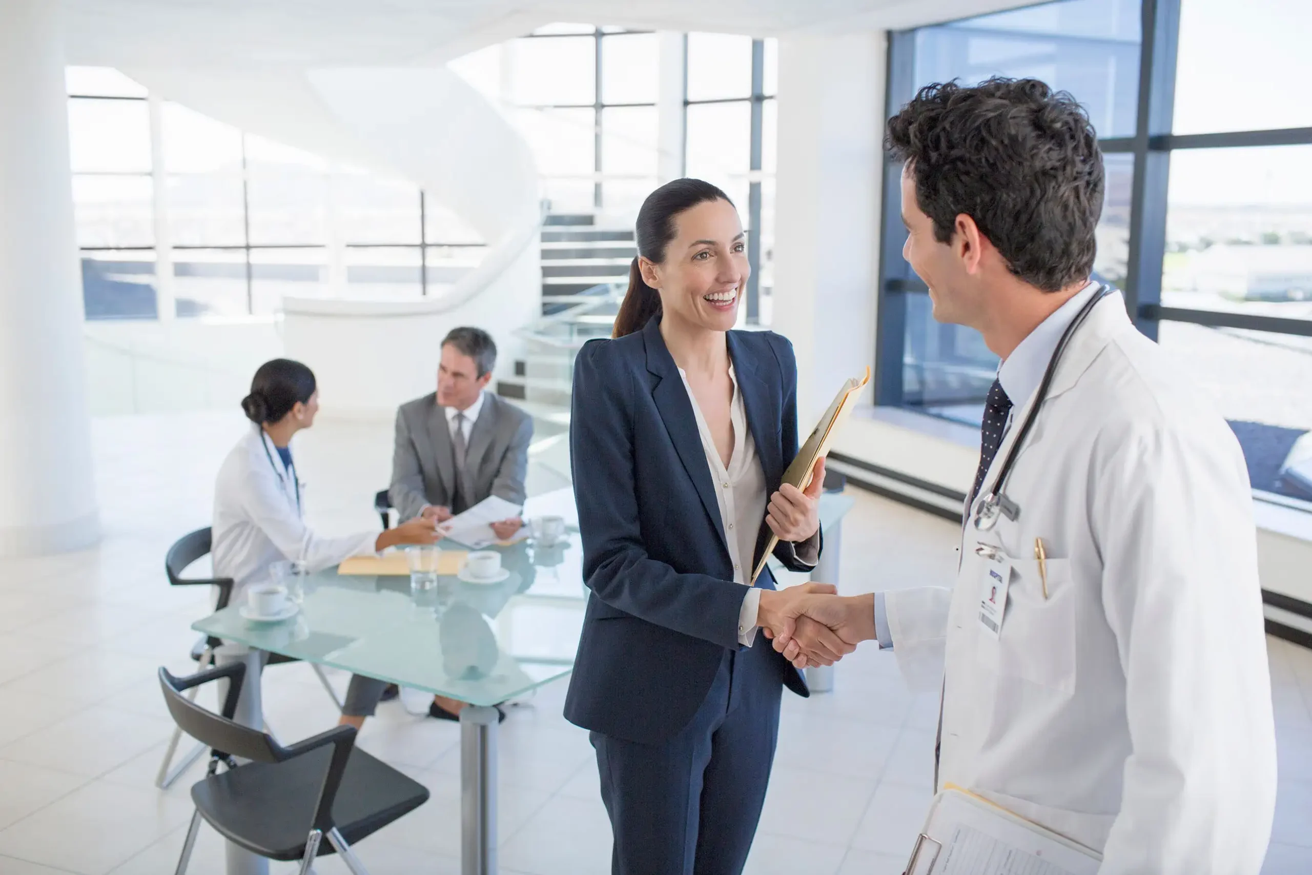 Businesswoman shakes hands with a doctor in a bright in the modern office