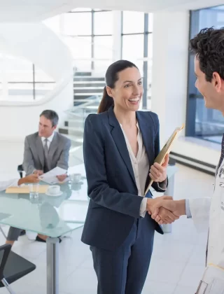 Businesswoman shakes hands with a doctor in a bright in the modern office