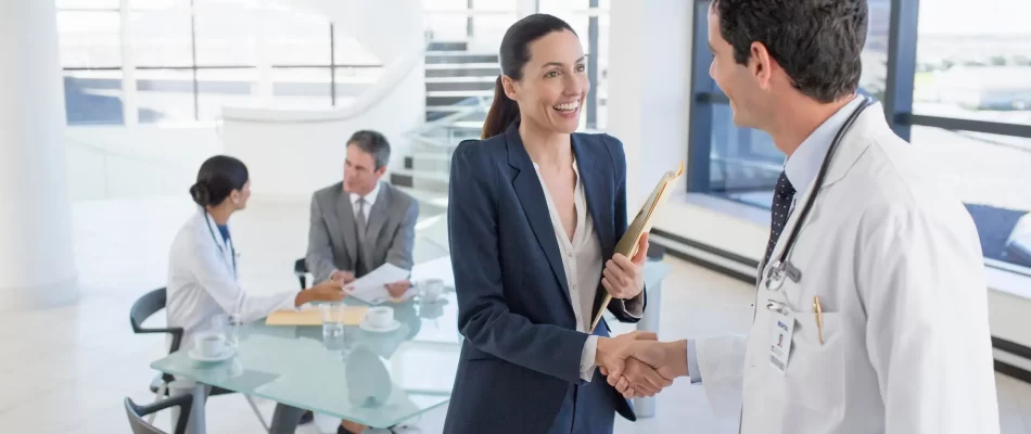 Businesswoman shakes hands with a doctor in a bright in the modern office